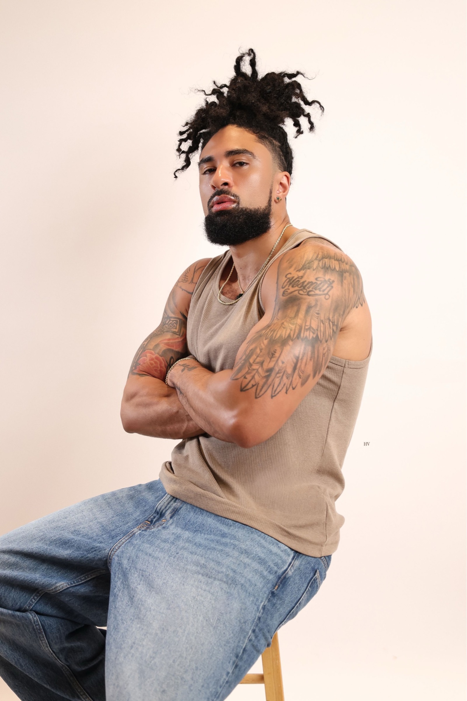 LaShawn seated in a taupe tank and jeans