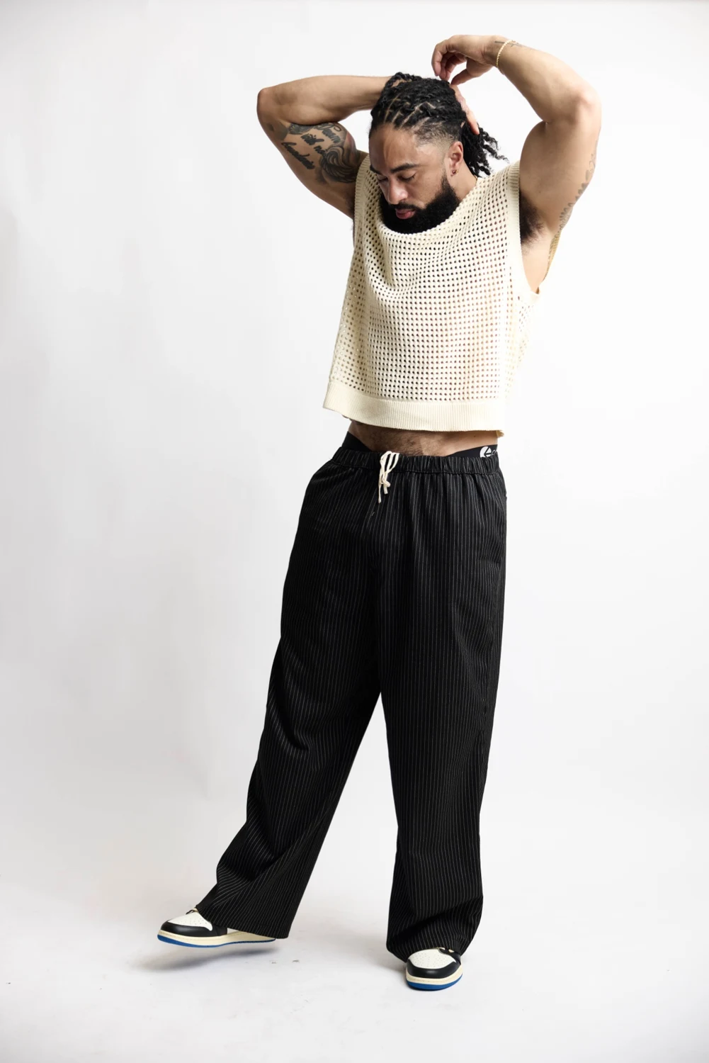 LaShawn in a cream knit top, wide-leg black trousers and sneakers
