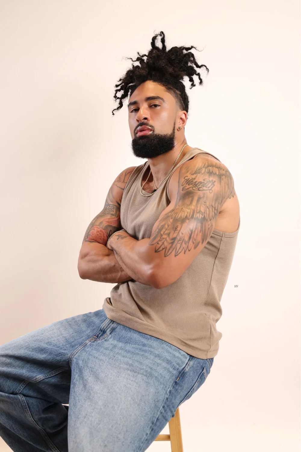 LaShawn seated in a taupe knit tank and jeans